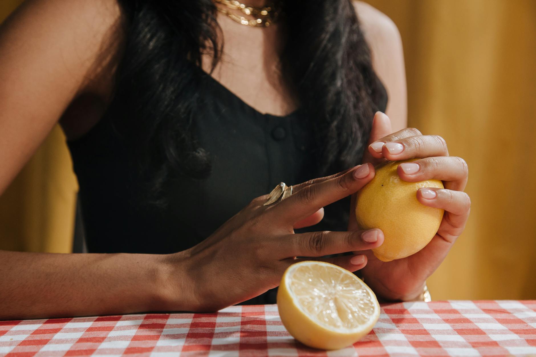 Une main tenant un vibromasseur coloré parmi d'autres jouets sexuels sur une table